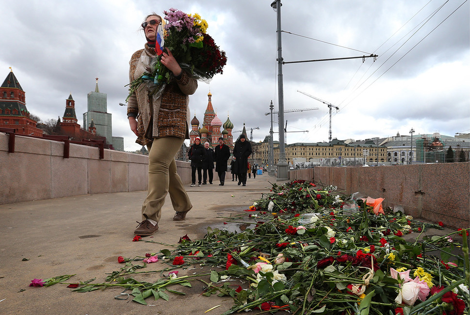 Активист приводит в порядок мемориал на месте убийства политика Бориса Немцова на Большом Москворецком мосту, после того, как работники коммунальных служб перенесли цветы на другую сторону. Фото: Валерий Шарифулин/ТАСС
