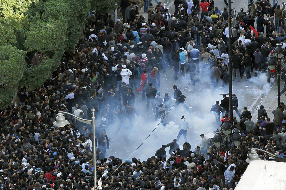 Столкновение полиции и протестующих в Тунисе, январь 2011 года. Фото: Christophe Ena / AP