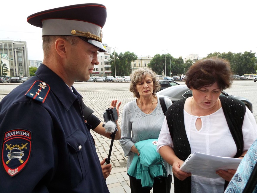 Елена Парий зачитывает неожиданно появившемуся полицейскому маршрут из уведомления